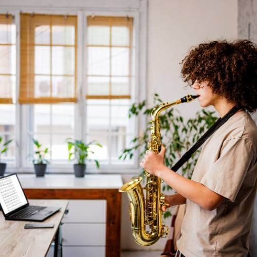Étudiant apprenant le saxophone à domicile à Dubaï avec des leçons de saxophone en ligne.